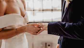 woman putting wedding ring on groom s finger