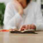 woman sitting behind the desk and looking at money and receipts